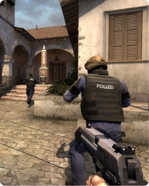 Játékmenet-felvétel egy rendőri egységről, amely egy Counter-Strike-küldetés során közeledik egy épülethez.